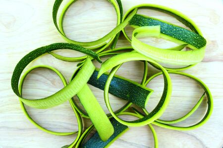 Zucchini slices on wooden background for a theme of food and healthy eatingの写真素材