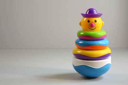 smiling clown made of multi-colored rings in studio on a gray background with copy space for text, toy for babies and toddlers education