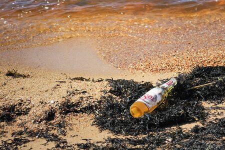 Riga, Latvia - May 5, 2018: Sol yellow beer bottle on the seashore on a summer dayの写真素材