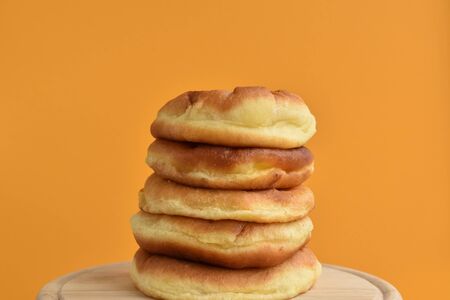 Bakery products, stacked on each other. Handmade lush buns- symbol of home wealth, well-being, growth in business. Vivid tangerine orange color backdrop.の写真素材