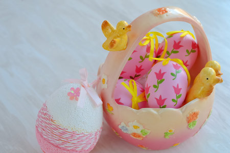 Easter ceramic basket with decorative pink eggs and chick figurines, festive home decor