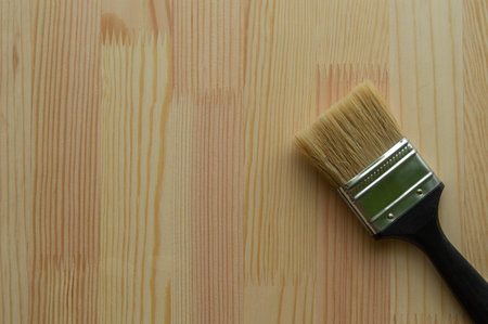 paintbrush on the background of a glued timber beams structure, ready to be painted or tinted, copy...