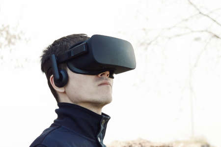 Portrait of young man with VR glasses in outdoorの写真素材