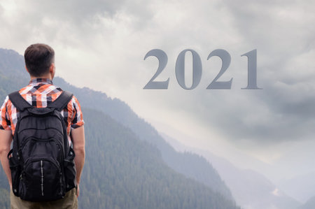 New year 2021 celebration, young man stands alone and sees dark stormy sky, concept of the spread of...