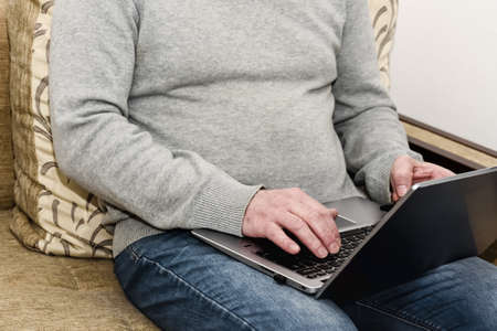 Man works at home on laptop via the Internet.の写真素材