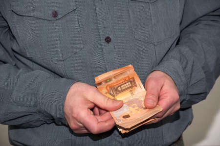 Man counting paper money. Planning, preparation and maintenance of a spending budgetの写真素材