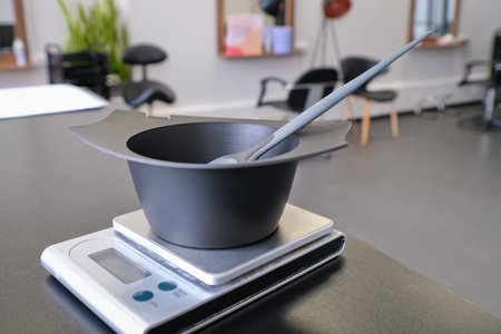 Mixing bowl and hair dye brush on electronic scale. Hair dye measuring and mixing kit. Hair coloring tools set. Professional instrument for hair colorist and hairstylist.の写真素材