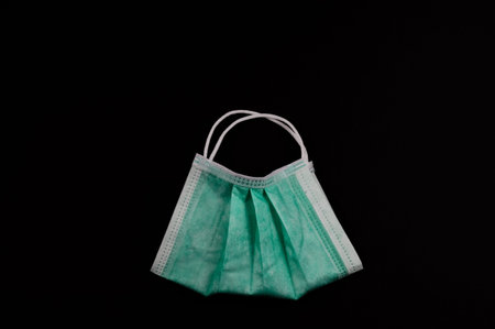 Face mask in the form of a bag with handles on a black background. The concept of using personal...