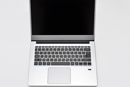Portable modern computer laptop with black screen, touchpad and keyboard for writing text. Notebook for online remote working, video conference and chatting on the internet.の写真素材