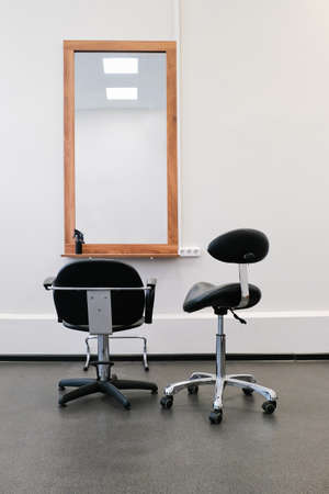 Hairdresser's armchair and mirror ready to receive visitors. The interior of the salon with hairdressing equipment and furniture.の写真素材