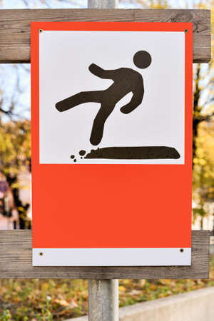 Road sign warns pedestrians about falling. Warning sign with falling man silhouette.の写真素材