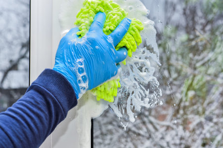 Sponge and foam on glass when cleaning and washing window. House cleaning works and services. Window...