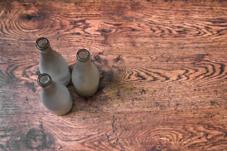 Top view of empty glass wine bottles standing on wooden floorの写真素材