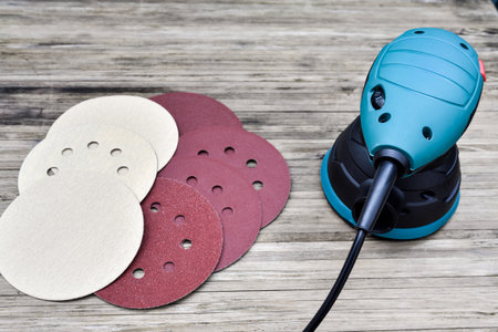 Electric portable disc grinder and round sandpaper. Random orbital sander with sanding discs.の写真素材