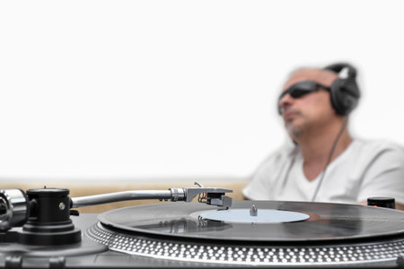 Vinyl player, turntable on the background of a blurred man in headphones listening to music