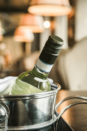 Close up view of bottle of white wine in an ice bucket served in a restaurantの写真素材