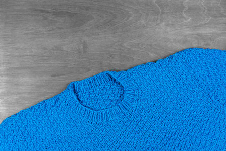 Warm handmade knitted blue wool sweater, copy space for text.