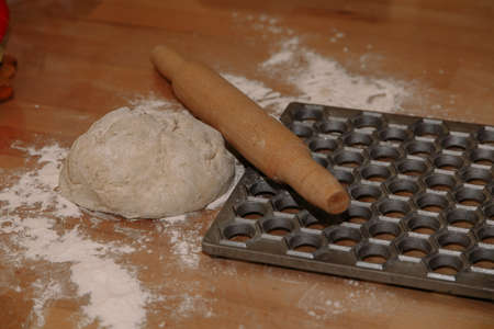 Woman sculpts homemade dumplings bear ears in the kitchen. Modeling dumplings closeup. Female hands sculpt dumplings.の写真素材