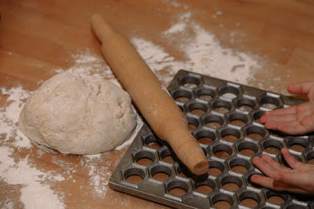 Woman sculpts homemade dumplings bear ears in the kitchen. Modeling dumplings closeup. Female hands sculpt dumplings.の写真素材