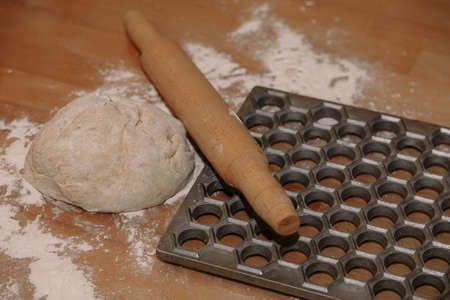 Woman sculpts homemade dumplings bear ears in the kitchen. Modeling dumplings closeup. Female hands sculpt dumplings.の写真素材