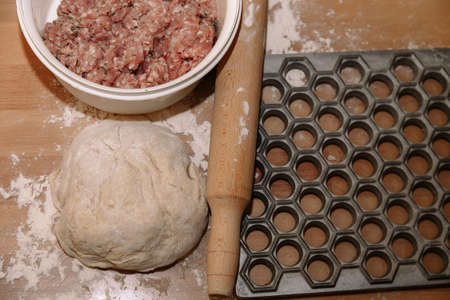 Woman sculpts homemade dumplings bear ears in the kitchen. Modeling dumplings closeup. Female hands sculpt dumplings.の写真素材