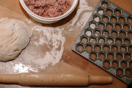 Woman sculpts homemade dumplings bear ears in the kitchen. Modeling dumplings closeup. Female hands sculpt dumplings.の写真素材