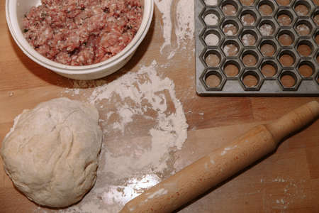 Woman sculpts homemade dumplings bear ears in the kitchen. Modeling dumplings closeup. Female hands sculpt dumplings.の写真素材