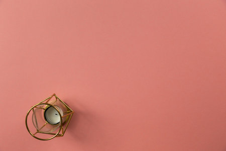 Top view of Christmas golden candle on pastel pink background.Holiday festive celebration greeting card with copy space to addng textの写真素材