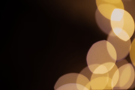 Golden abstract bokeh on a black background, bright lights