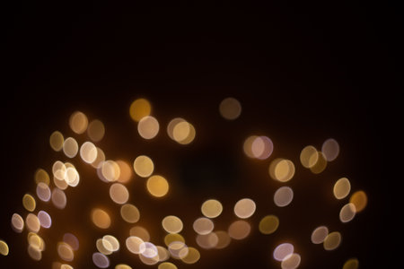 Golden abstract bokeh on a black background, bright lightsの写真素材
