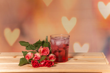 Pink roses on a wooden background, white place for text, easel, pink background for the holiday of February 14 or March 8, Valentines Day, pink drink in a glassの写真素材
