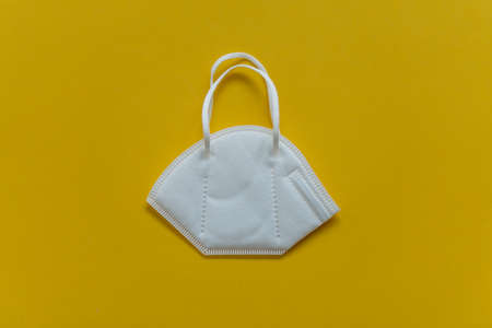 FFP3 mask lie on the table, top view, on a yellow background, FlatLayの写真素材
