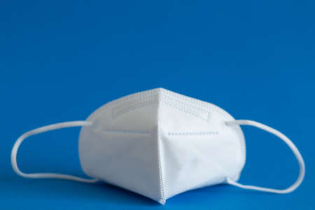 FFP3 mask, nasal drops, thermometer, tablets, various medicines lie on the table, top view, on a blue background, FlatLayの写真素材