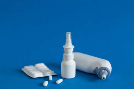 FFP3 mask, nasal drops, thermometer, tablets, various medicines lie on the table, top view, on a blue background, FlatLayの写真素材