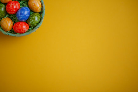 Easter card. Flat lay composition with easter eggs in a basket on yellow background. Top viewの写真素材