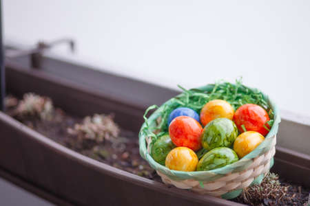 Easter card. Flat lay composition with easter eggs in a basket on wooden background. Top viewの写真素材