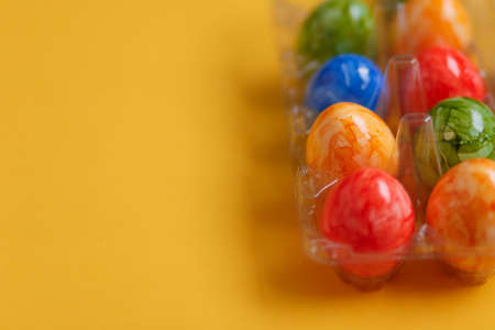 Easter card. Flat lay composition with easter eggs in plastic packaging on yellow background. Top viewの写真素材