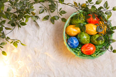 Easter card. Flat lay composition with easter eggs in a basket on white background.の写真素材