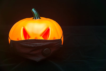 Wicked Halloween pumpkin with scary red eyes in face mask. Halloween 2020 celebration with...