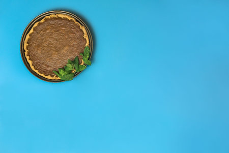 Absolutely amazing Thanksgiving background. Manmade pumpkin pie with fresh mint leaves on light blue...