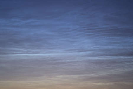 Beautiful closeup view of stars visible through very rare noctilucent clouds seen in Dublin, Ireland on summer solstice of 2021 before midnight. Details of NLC. Night shiningの写真素材