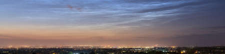 Beautiful panoramic view of very rare noctilucent clouds and stars shining through them seen in Dublin, Ireland on summer solstice of 2021 before midnight. Details of NLC. Night shining panoramaの写真素材