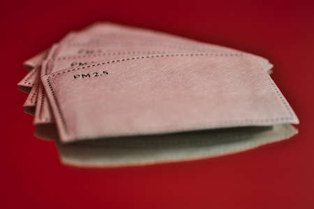 Beautiful closeup creative view of white PM 2.5 filters on red reflective background. Copy space. Soft and selective focus. High resolutionの写真素材