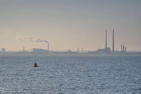 Beautiful hazy evening view of Dublin Waste to Energy (Covanta Plant), Poolbeg CCGT and Pigeon House Power Station view from Dun Laoghaire harbor, Dublin, Ireland. Soft and selective focusの写真素材