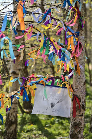 Be Love, We Are Love. Beautiful closeup view of many ribbons of different colors tied on branches of spring birch tree seen at university campus, Dublin, Ireland. Soft and selective focusの写真素材