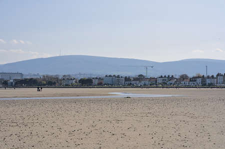 Beautiful bright view on South Dublin and the Mountains seen from Sandymount Beach, Dublin, Ireland during lowest tide. Walking people. Open spaces. High resolutionの写真素材
