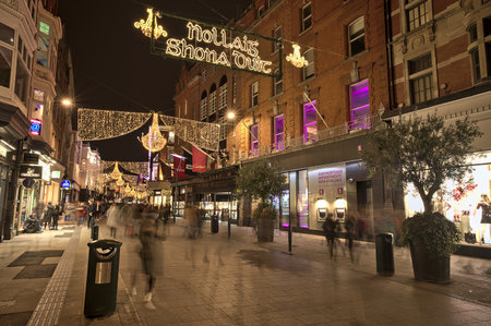 Dublin, Ireland - November 13. 2021: Beautiful evening view of Nollaig shona dhuit Christmas lights. Merry Christmas signboard written in Irish (Gaelic) language on Grafton Street. Crowded streetのeditorial素材