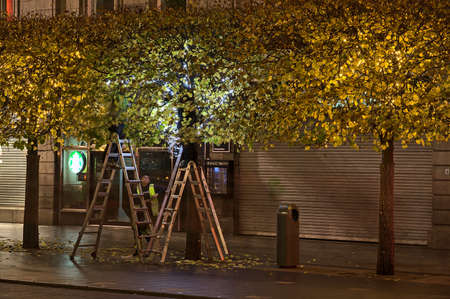 Dublin, Ireland - November 13, 2021: Beautiful evening view of Christmas decoration process on O'Connell Street. Workers hanging light on autumn treesのeditorial素材