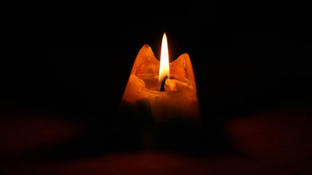 Single candle on dark background. Memory calm glow light closeup. Romantic.