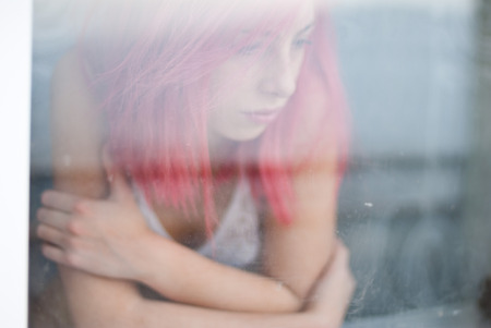 Pink hair young girl intimate portraits through the windowの写真素材
